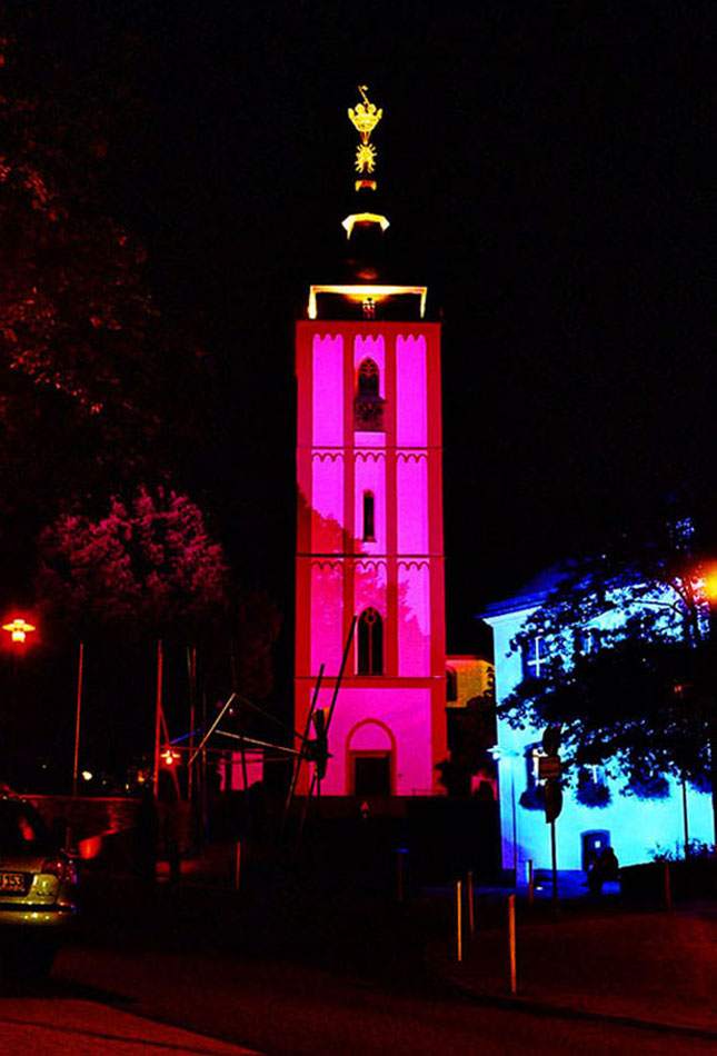 Nikolaikirche Siegen magenta illuminiert, benachbartes Gebäude in Blau angestrahlt