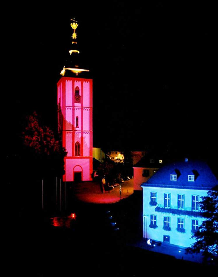Nikolaikirche Siegen in Magenta illuminiert, benachbartes klassizistisches Gebäude in Blau